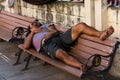 Homeless man sleeping peacefully on wooden bench