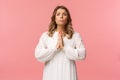 Portrait of hopeful clingy girlfriend, blond girl begging for favour in white dress over pink background, sobbing make