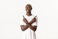 Portrait of hopeful smiling african-american guy, looking left pleased, pointing fingers sideways, standing white