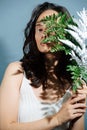 Portrait of a stunning woman holding fern over face and vitiligo eyelashes