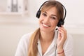 Portrait Of Hotline Operator In Headset Smiling Sitting In Office Royalty Free Stock Photo