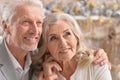 Hugging senior couple with blurred Christmas decorations Royalty Free Stock Photo