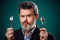 A portrait of hungry man in suit holding spoon and fork Royalty Free Stock Photo