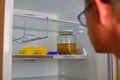 Portrait of a hungry man looking for food in refrigerator. Man looking inside an empty refrigerator Royalty Free Stock Photo