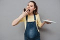 Portrait of a hungry pretty pregnant woman eating chocolate cake Royalty Free Stock Photo