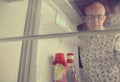 Portrait of a hungry senior man looking for food in refrigerator. Eating and diet concept - confused mature-aged man Royalty Free Stock Photo