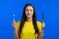 Portrait of hungry woman with fork and knife. Lady with anticipation waiting for serving dinner dishes with cutlery on Royalty Free Stock Photo