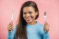 Portrait of hungry woman with fork and knife. Mature lady waiting for serving dinner dishes with cutlery on pink studio Royalty Free Stock Photo