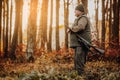 Portrait of hunter or ranger with gun or rifle in the forest looking out or hunting of some venison, hunting period Royalty Free Stock Photo
