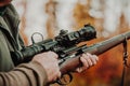 Portrait of hunter or ranger with gun or rifle in a forest looking out or hunting of some venison, hunting period Royalty Free Stock Photo