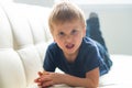 Portrait of hysterical boy. Upset caucasian kid crying at home.