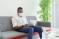 Portrait of ill black american man wearing a face mask for corona virus and health care concept working from home with computer Royalty Free Stock Photo