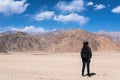 A beautiful Asian woman tourist standing and turn back in front of mountain and blue sky background Royalty Free Stock Photo