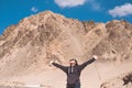 Portrait image of a beautiful Asian woman tourist stretching arms and standing in front of mountain Royalty Free Stock Photo