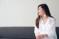 Portrait image of a beautiful Asian woman on white dress sitting with feeling happy