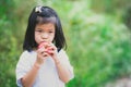 Portrait image child 4-5 years old. Asian little girl is about to eat an apple. Children do not like to eat fruit. Empty space.