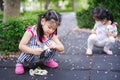 Portrait image child 5-6 years old. Children were sitting with interest collecting flowers that had fallen on ground.