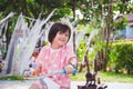 Portrait image child 5-6 years old. Kid riding bicycle on park. Sweet smile. Active girl playing in playground.