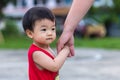 portrait image of Happy and cute Asian Chinese baby boy holding mother hand at park during evening Royalty Free Stock Photo