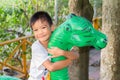Portrait image of kid 5 years old. Happy Asian child boy playing with dinosaur toy at the playground. Royalty Free Stock Photo
