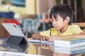 Asian student child boy using and touching smart pad or tablet for do his homework and online learning E-learning. Royalty Free Stock Photo