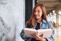 A young beautiful asian woman sitting and reading book Royalty Free Stock Photo