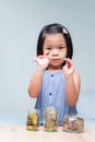 Portrait imaged. Asian child girl holding silver coins in her hands. Save money for the future. Coins cash in grass jar. Royalty Free Stock Photo