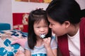 Portrait imaged happy Asian family in birthday child. Little girl happiness with cake. Kid eating snowflake candy. Royalty Free Stock Photo