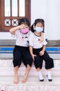 Portrait imaged kids 5 years old. Two cute girls wearing white face masks, children hugging each other`s necks.