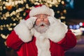 Portrait of impressed santa claus pouted lips arms touch glasses staring cant believe midnight tree garland city center