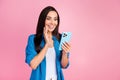 Portrait of impressed woman wear stylish shirt astonished staring at smartphone choose product in eshop on pink