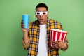 Portrait of impressed young man watch movie 3d glasses hold popcorn soda drink isolated on green color background Royalty Free Stock Photo