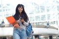 Indian female university student walking in the city with mobile phone Royalty Free Stock Photo