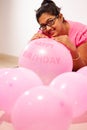 Portrait of an indian girl dressed in pink dress with pink balloons on her birthday with selective focus on balloon