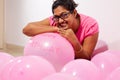 Portrait of an indian girl dressed in pink dress with pink balloons on her birthday with selective focus on balloon