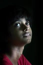 Portrait of an Indian little girl with short hair. Beautiful eye of a child on black background. Dramatic look of a little girl in Royalty Free Stock Photo