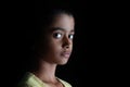 Portrait of an Indian little girl with short hair. Beautiful eye of a child on black background. Royalty Free Stock Photo