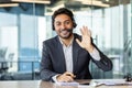 Portrait of an Indian male businessman in a business suit and headset sitting in the office at the table and talking on Royalty Free Stock Photo