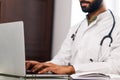 Portrait of indian man doctor talking to online patient on laptop online consultation Royalty Free Stock Photo