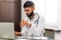 Portrait of indian man doctor talking to online patient on laptop online consultation Royalty Free Stock Photo