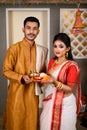 Portrait of Indian men dressed in kurta pajama with beautiful Indian woman wearing traditional Indian saree, gold jewellery and