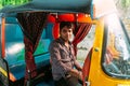Portrait of Indian Yellow Rickshaw Car driver sitting in the car while raining in Varanasi, India