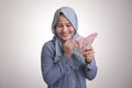 Indonesian Muslim Woman Holding Rupiah Money and Thinking Royalty Free Stock Photo