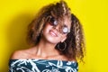 Portrait indoors of a young afro american woman in sunglasses. Yellow background. Lifestyle. Casual clothing Royalty Free Stock Photo