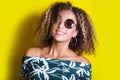 Portrait of a young afro american woman in sunglasses. Yellow background. Lifestyle. Royalty Free Stock Photo