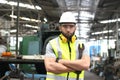 Portrait of industrial engineer worker wearing helmet and safely glasses standing with arms crossed, holding wrench and working at