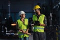 Portrait of industrial inspectors with tablet doing a general check up and talking indoors at metal workshop.