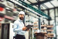 A portrait of an industrial man engineer with clipboard standing in a factory. Royalty Free Stock Photo