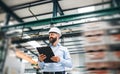 A portrait of an industrial man engineer with clipboard standing in a factory. Royalty Free Stock Photo