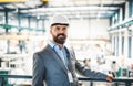 A portrait of an industrial man engineer standing in a factory. Royalty Free Stock Photo